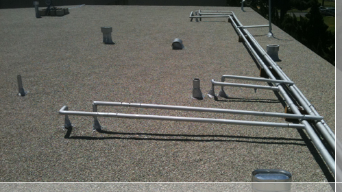 Plumbing pipes running the roof with insulation and coating applied - El Segundo